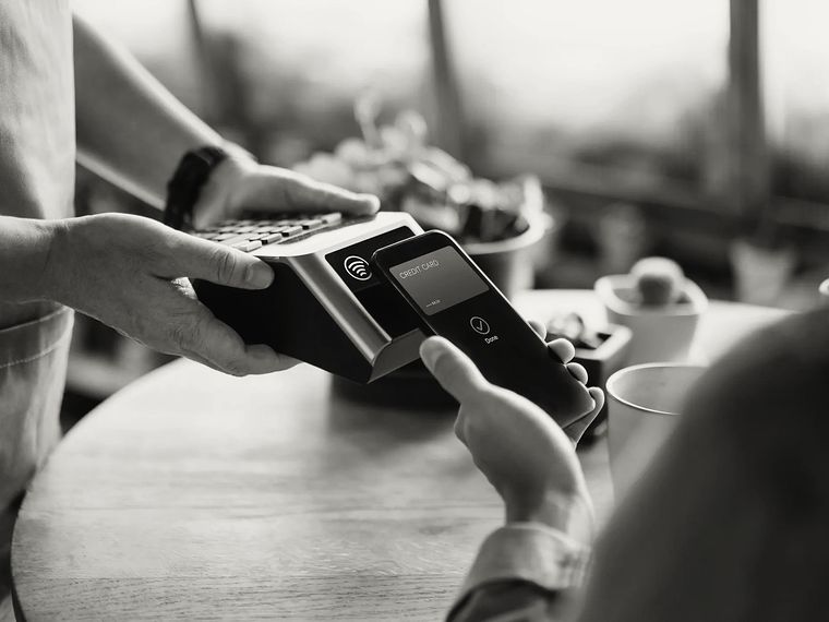 A customer paying by holding a phone to a card terminal.