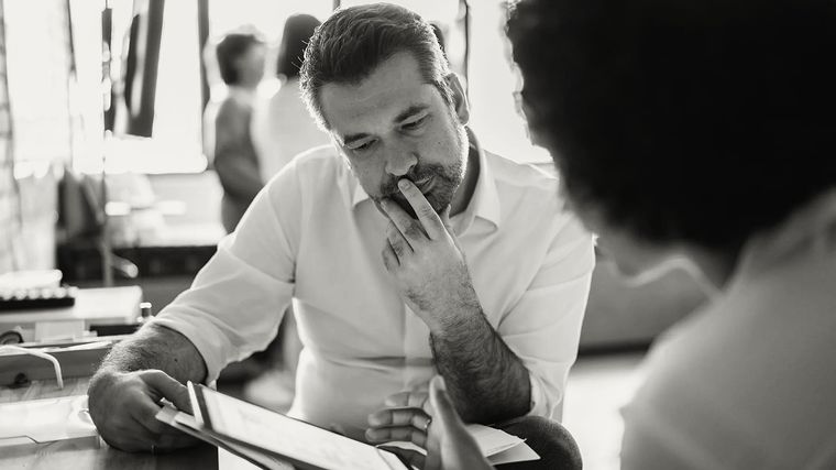 Two colleagues going over a document on a tablet.